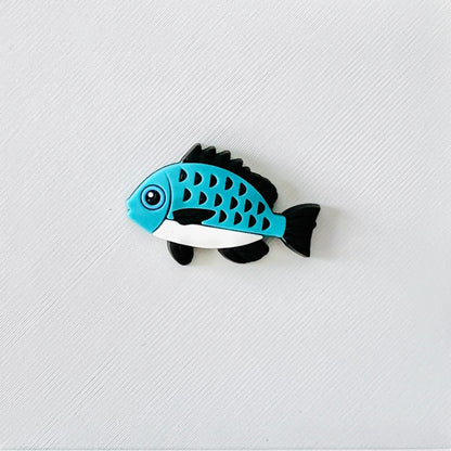 Blue and white fish charm with black fins, detailed scales, perfect for adding a fun aquatic touch to footwear.