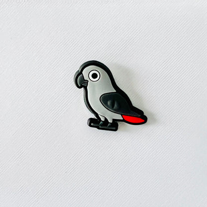 Charming grey parrot shoe charm with realistic features and a pop of red on its tail, perfect for bird lovers.