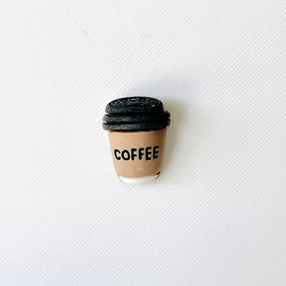 Adorable brown coffee cup charm with a white base and "COFFEE" printed, perfect for adding flair to your shoes!