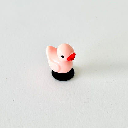 Adorable pink duck charm with a cheerful expression, perfect for adding whimsy to shoes or as a charming gift.