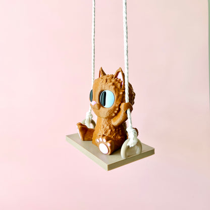 Adorable 3D-printed cat with big eyes happily swinging on a small platform, adding whimsy to any space.
