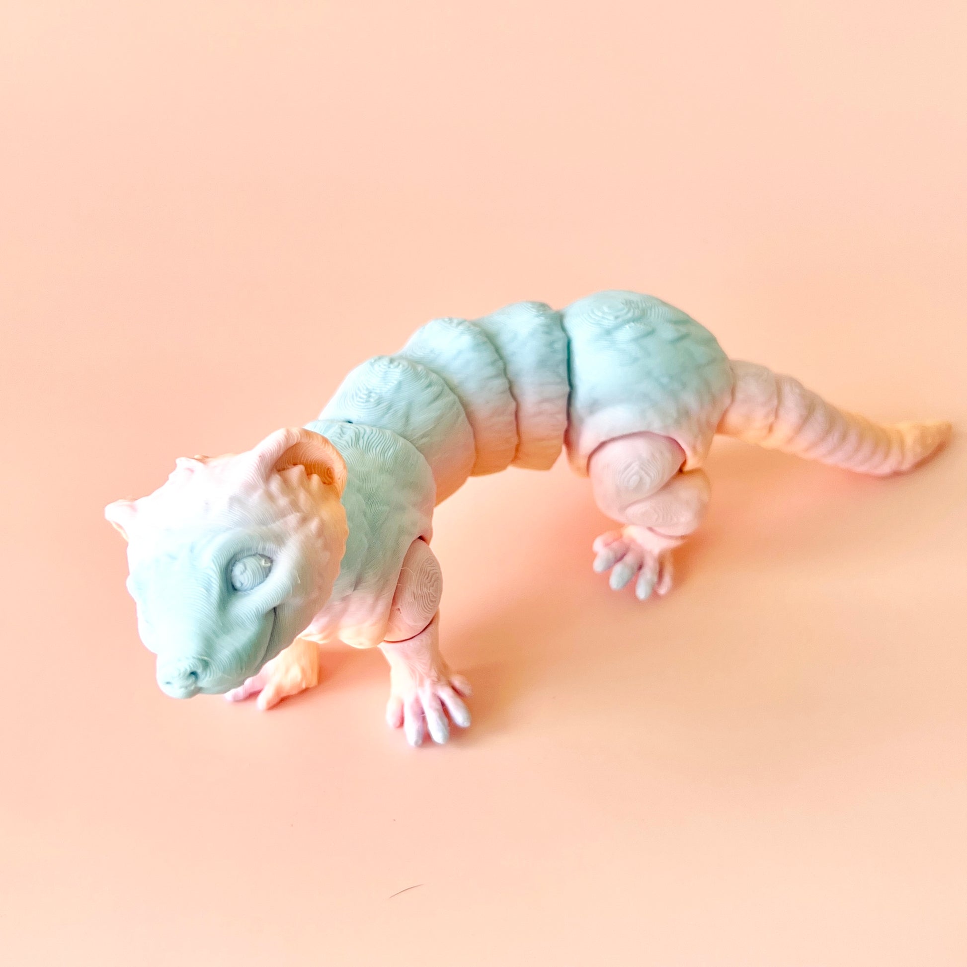A playful, articulated ferret figurine in soft pastel colors, showcasing intricate details and a charming expression.