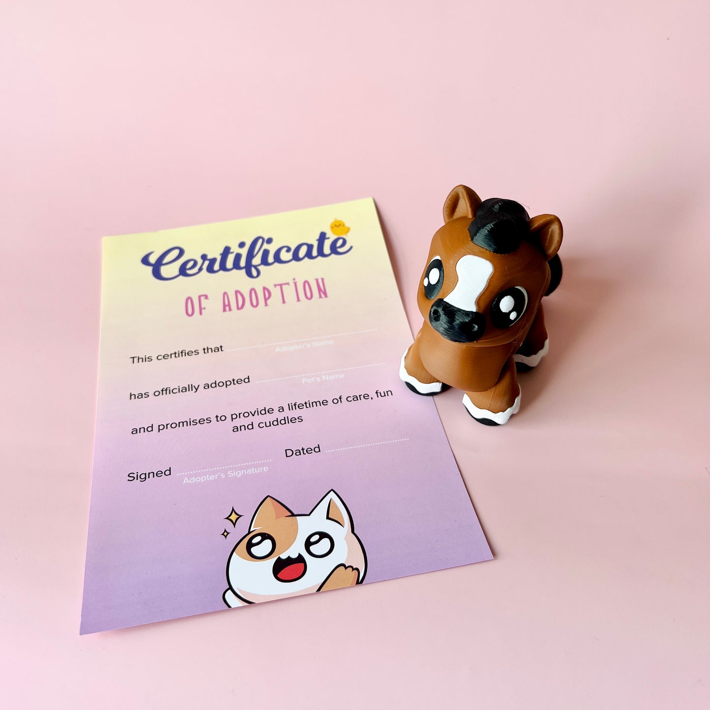 A playful horse figurine next to a colorful adoption certificate on a soft pink background.