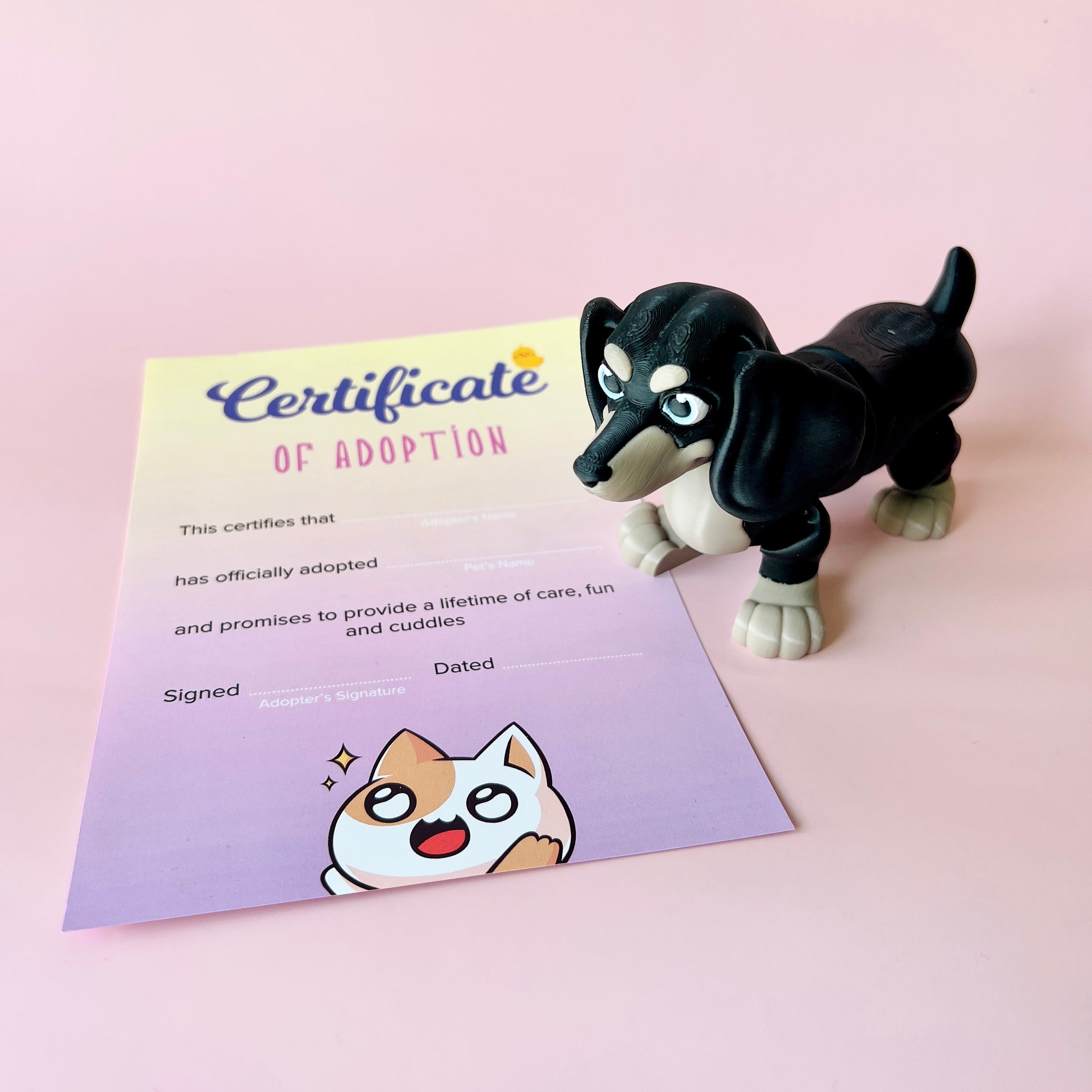 A playful black and tan dog figurine beside a colorful adoption certificate on a soft pink background.