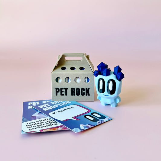 A pastel blue character with crystal-like features beside a small carrier and colorful adoption cards on a soft pink backgrou