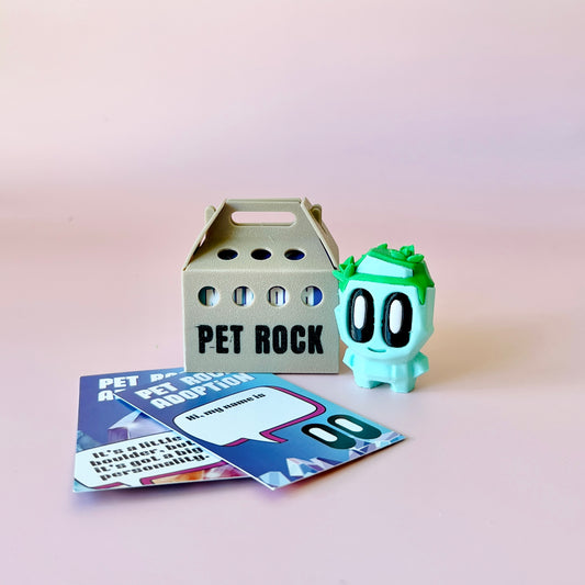 A whimsical green character with large eyes beside a gray carrier and colorful adoption cards on a pink background.