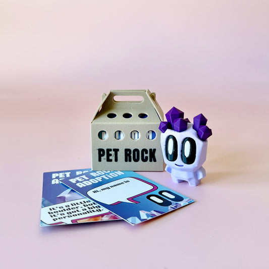 A whimsical character with purple crystals on its head beside a cardboard carrier and colorful adoption cards.