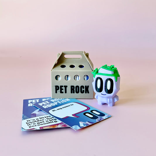 A whimsical purple figure with a green top, accompanied by a beige carrier and colorful adoption cards on a soft pink backgro