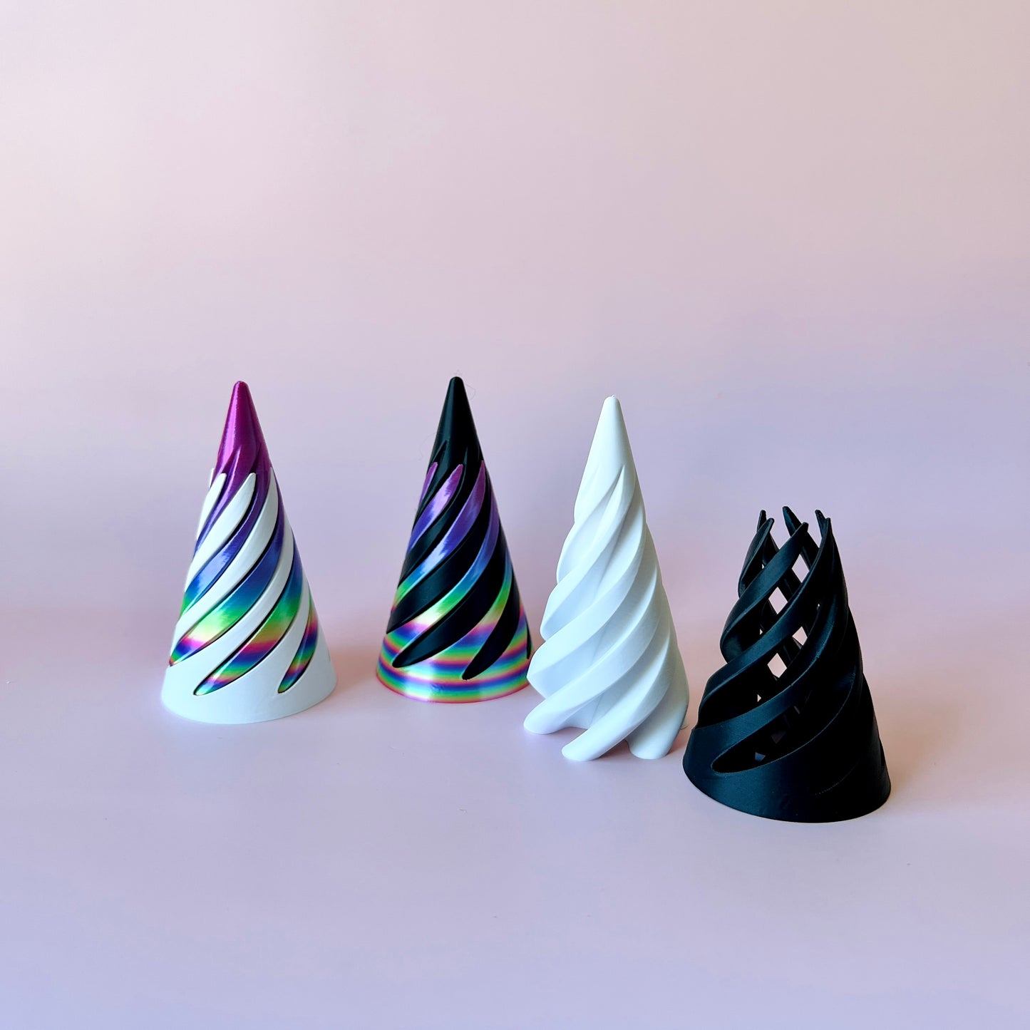 Four spiraled cones in vibrant colors, arranged against a soft pink background, showcasing a playful aesthetic.