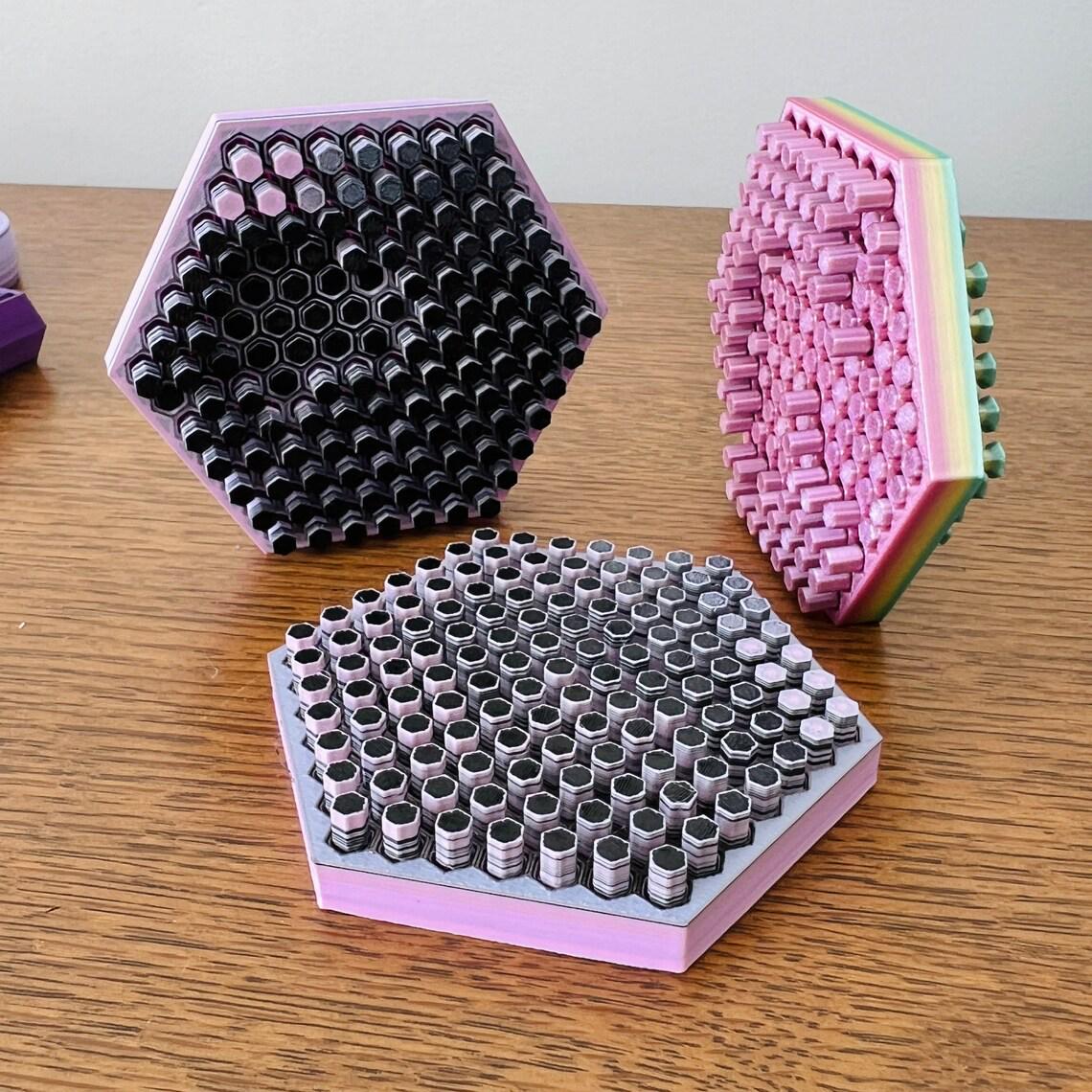 Colorful 3D-printed fidget shapes including hexagons and pin cushions, showcasing unique patterns and textures.