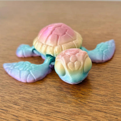 Colorful 3D-printed sea turtle figurine with detailed shell and flippers, resting on a wooden surface.