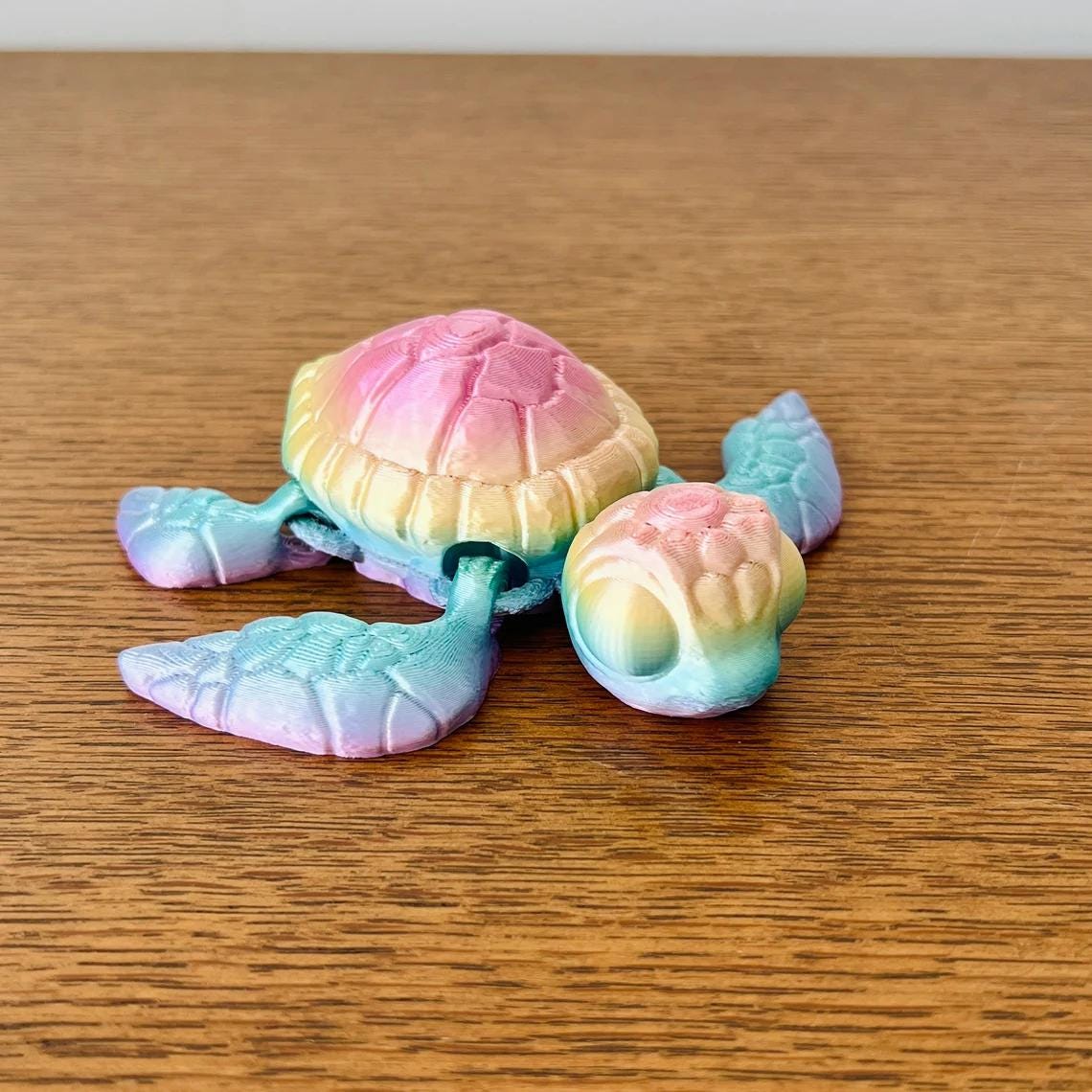 Colorful 3D-printed sea turtle figurine with intricate details, showcasing shades of pink, blue, and yellow.