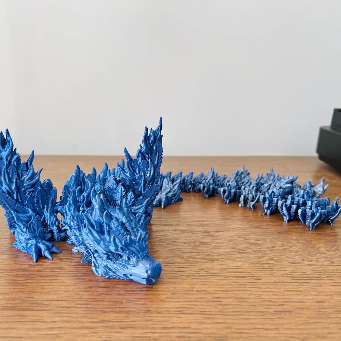 Majestic blue Phoenix Dragon with intricate detailing, showcasing powerful wings and a striking, elongated body.