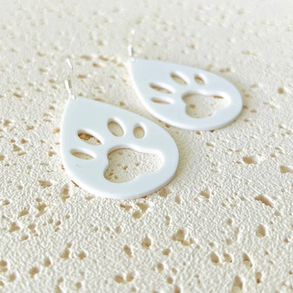 White paw print dangle earrings with sterling silver hooks, featuring a playful design, perfect for everyday wear.