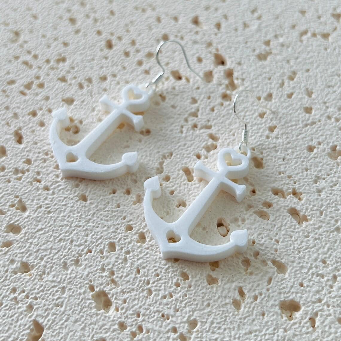White anchor dangle earrings with sterling silver hooks, perfect for a nautical style, adding elegance and movement.
