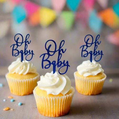 Playful "Oh Baby" toppers in navy atop frosted yellow cupcakes, set against a colorful, festive backdrop. Perfect for baby sh