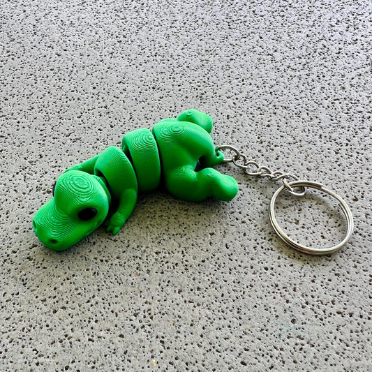 Vibrant green T-Rex keychain with detailed texture, perfect for adding a fun prehistoric touch to your accessories.
