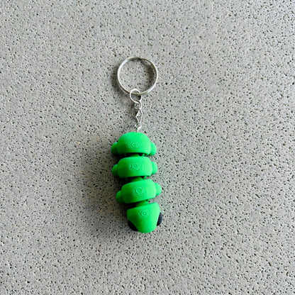 Whimsical green caterpillar keychain with a silver ring, perfect for adding charm to keys or bags.