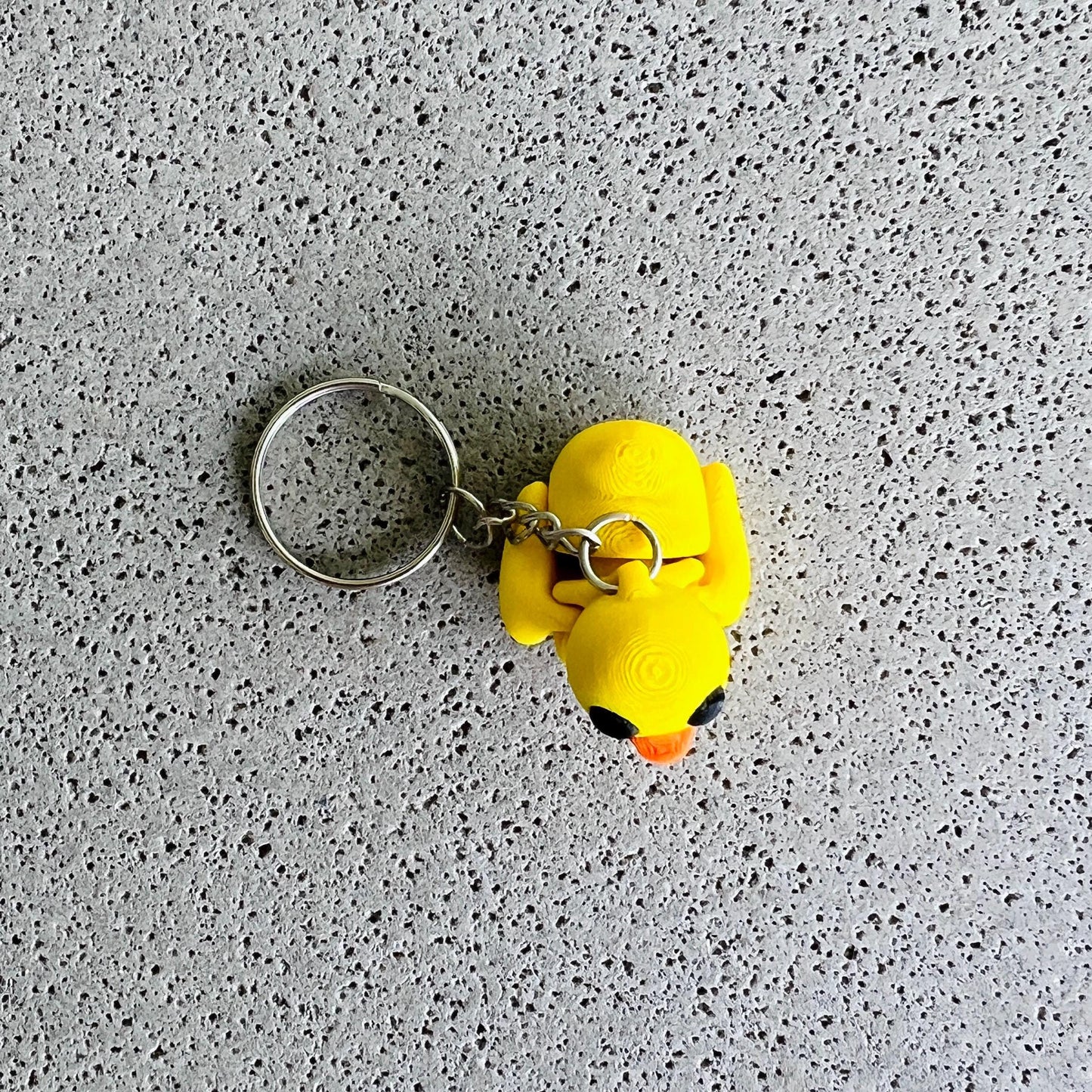 Bright yellow duck keychain with playful features, perfect for adding fun to your keys or bags.