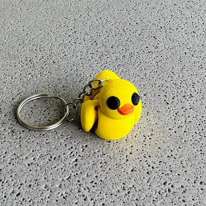 Bright yellow duck keychain with large black eyes and orange beak, perfect for adding fun to keys or bags.