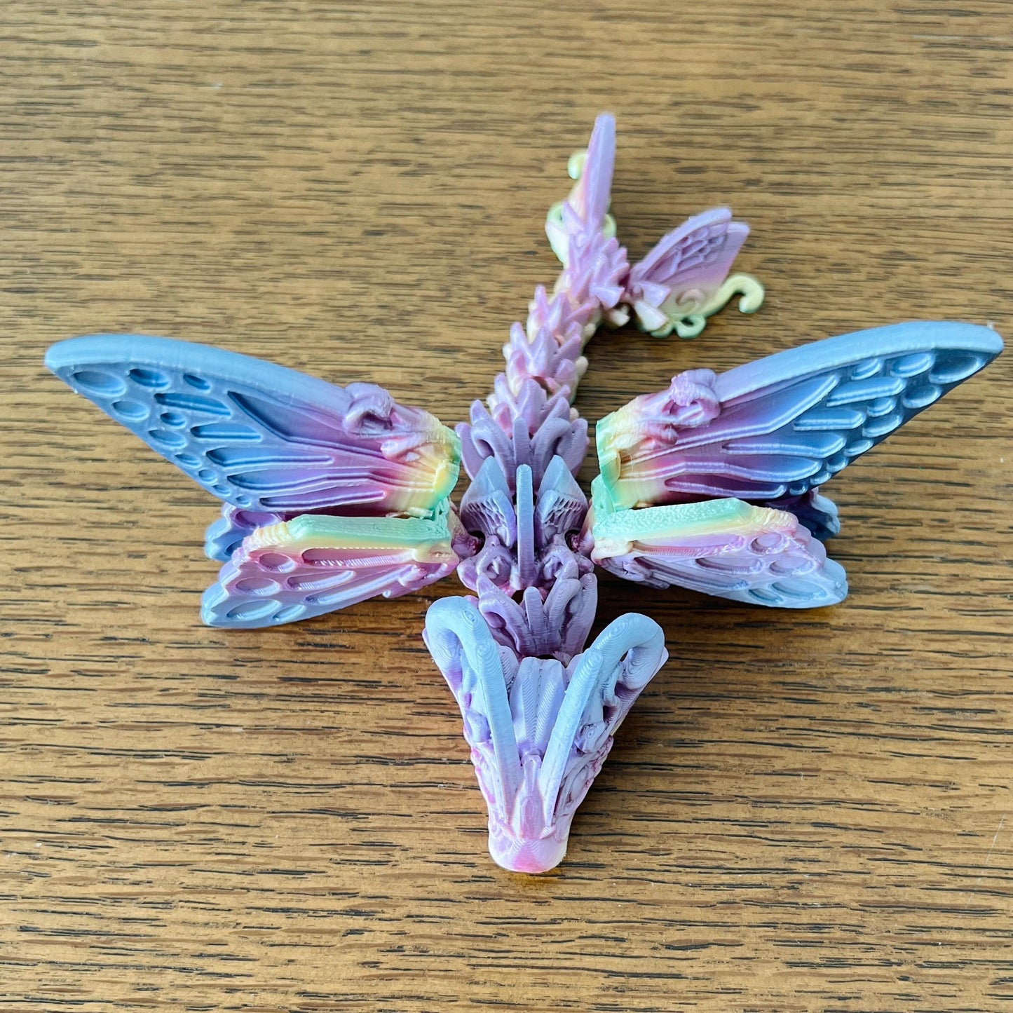 Delicate Butterfly Dragon Tadling with intricate, colorful wings, blending whimsical charm and mythical allure.