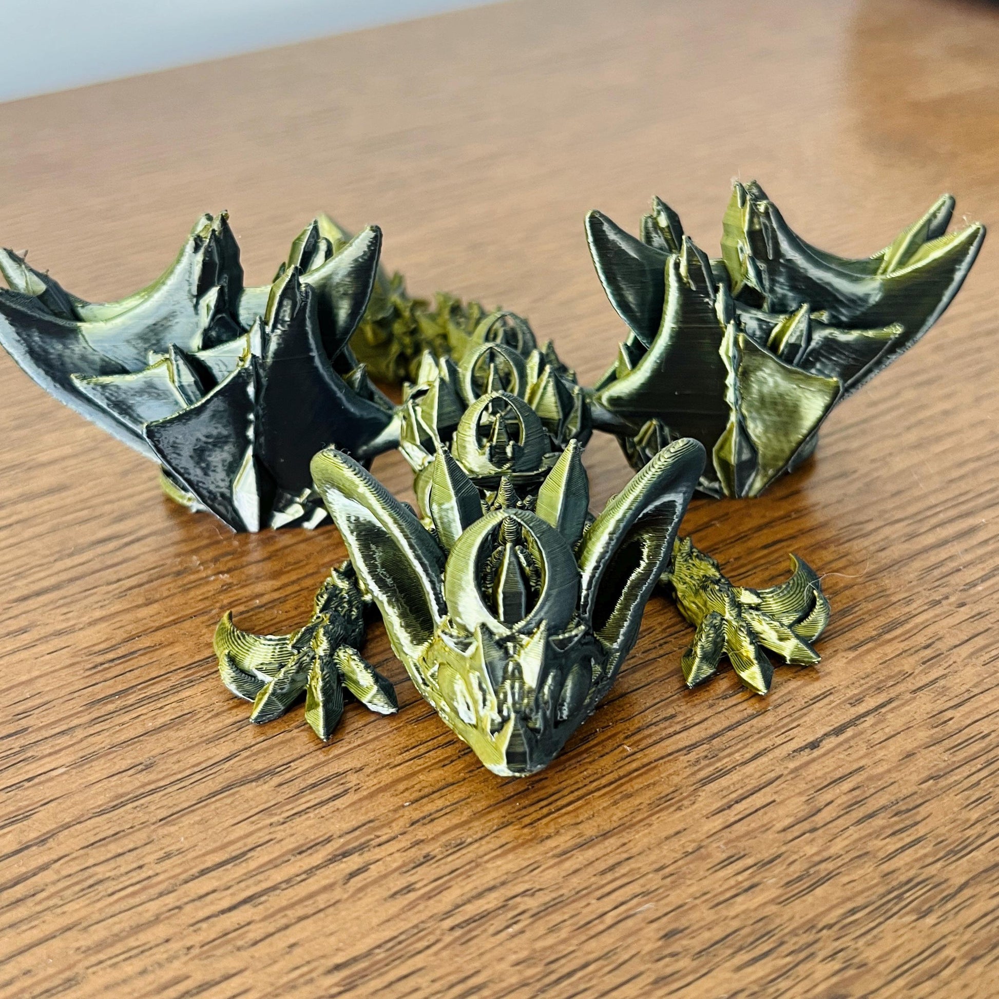 A dark dragon with intricate details and bat-like wings, evoking the allure of the night, rests on a wooden surface.