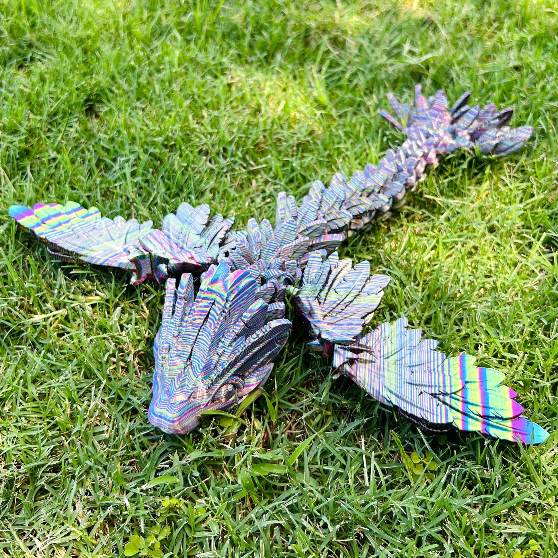 A sleek, winged dragon with intricate patterns and vibrant colors rests on lush green grass, embodying elegance and power.