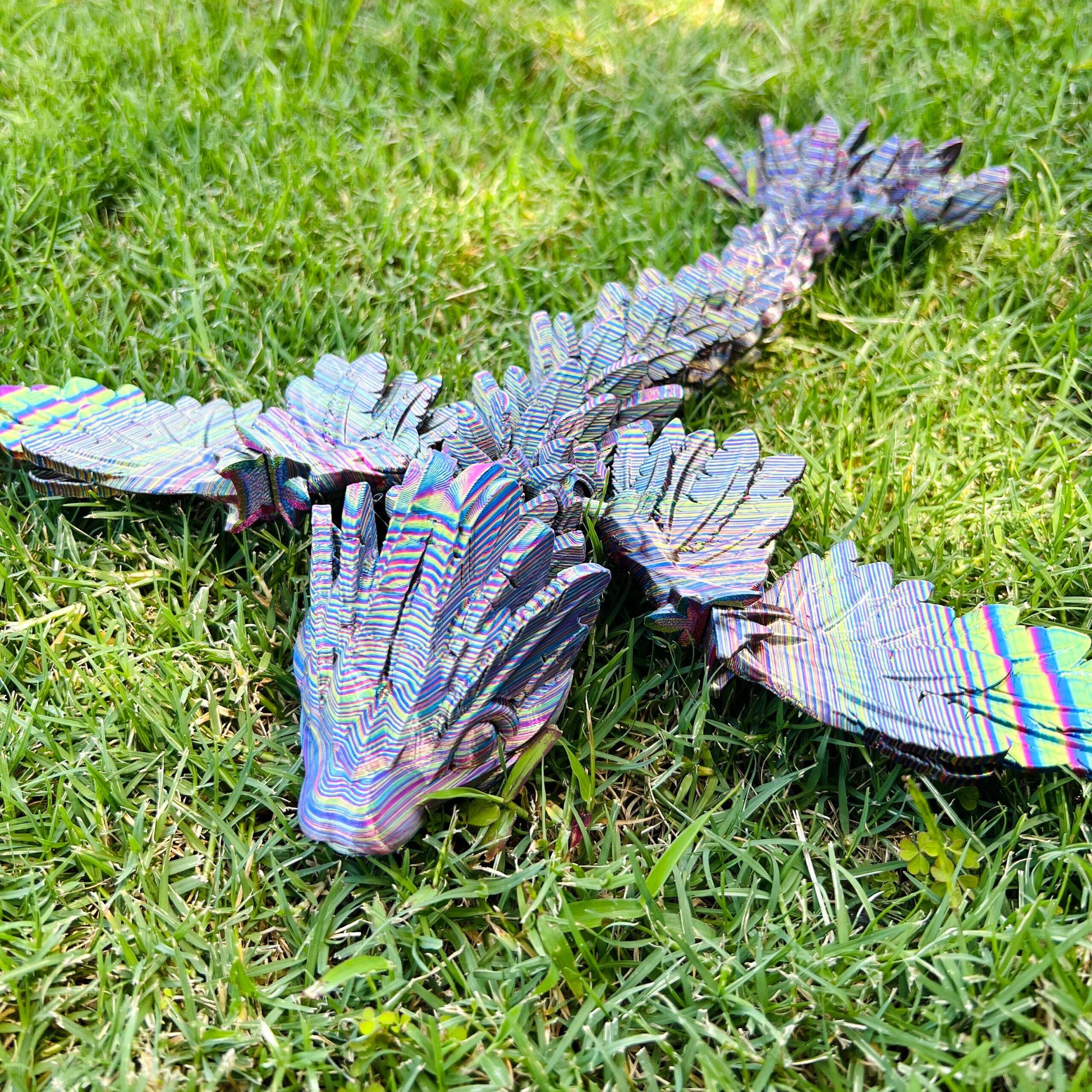 Sleek winged serpent dragon in vibrant colors, resting on lush green grass, showcasing intricate details and dynamic form.