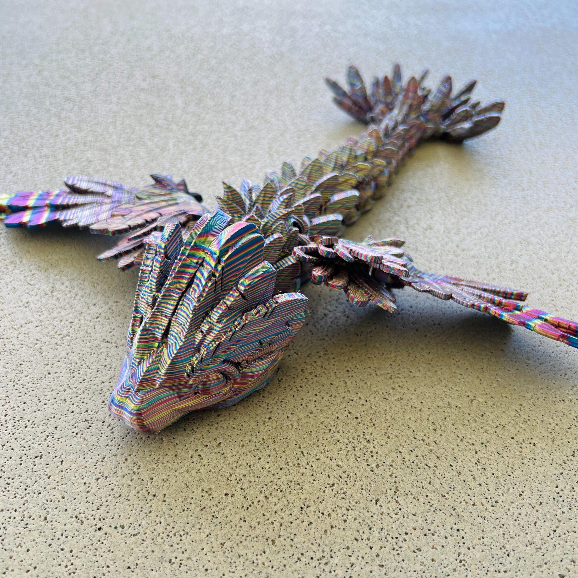 Colorful, winged serpent dragon with intricate scales and wings, poised on a textured surface, exuding a mystical aura.