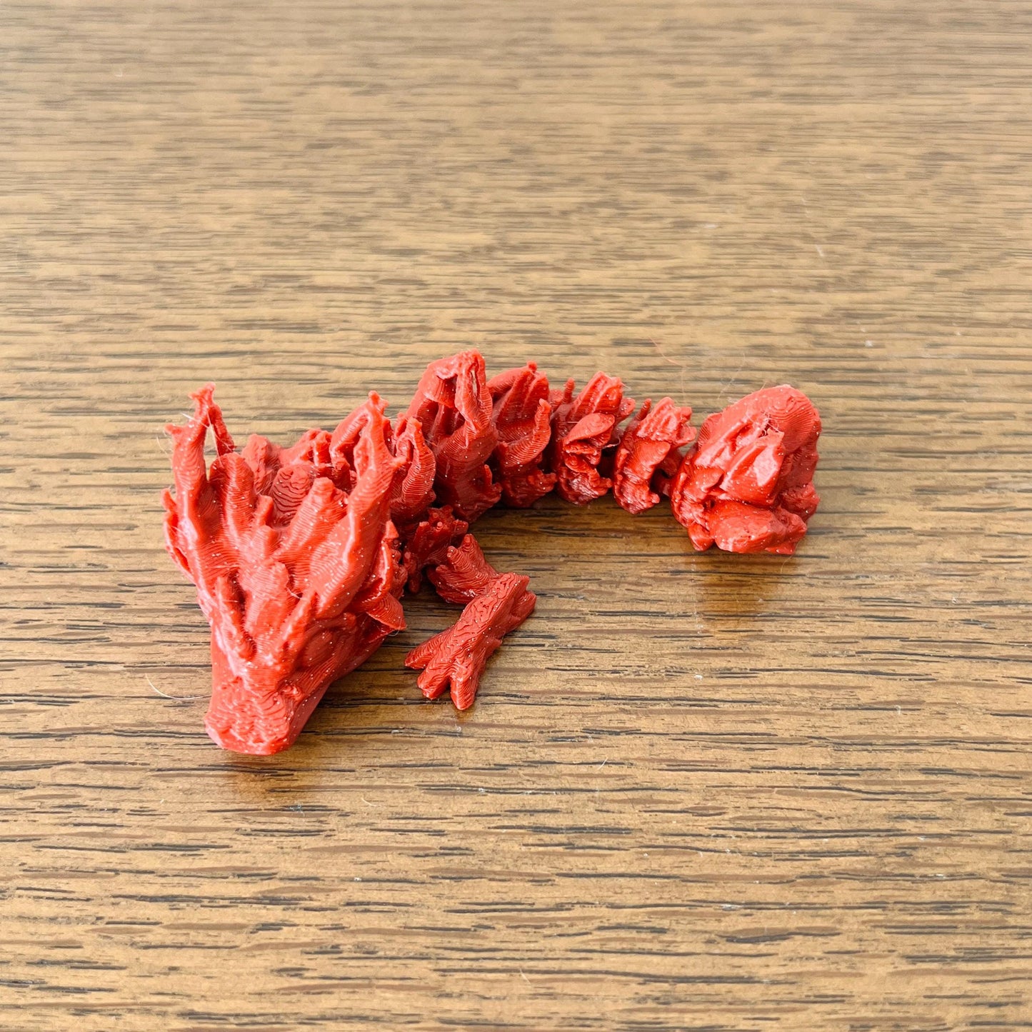 Mini Woodland Dragon features intricate details in vibrant red, evoking a magical forest creature.