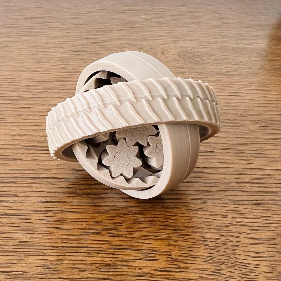 A tactile 3D-printed fidget in unique shapes, showcasing vibrant colors and intricate patterns on a wooden surface.