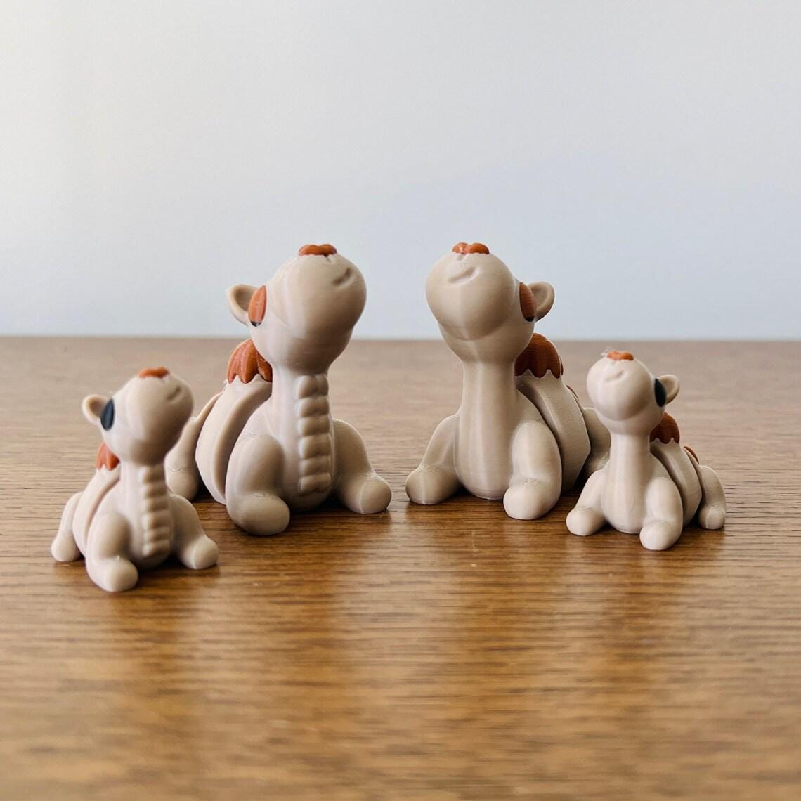 Four cute, articulated camels in varying sizes with cheerful expressions, crafted from eco-friendly material.