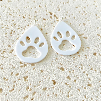 White paw print dangle earrings featuring sterling silver hooks, perfect for adding charm to any outfit.