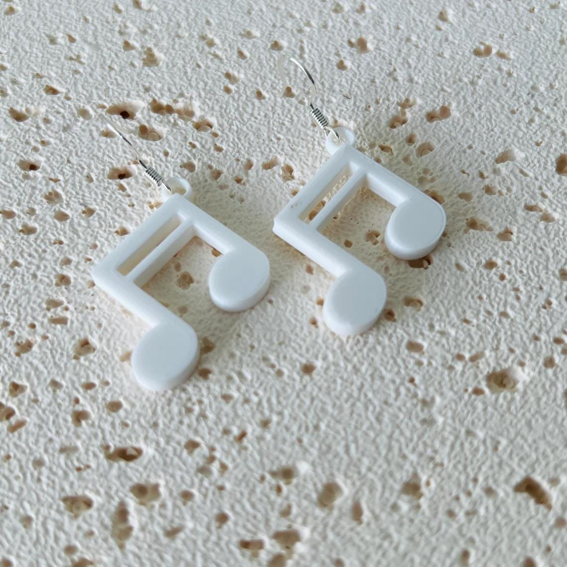 White music note dangle earrings with 925 sterling silver hooks, showcasing an elegant, lightweight design.