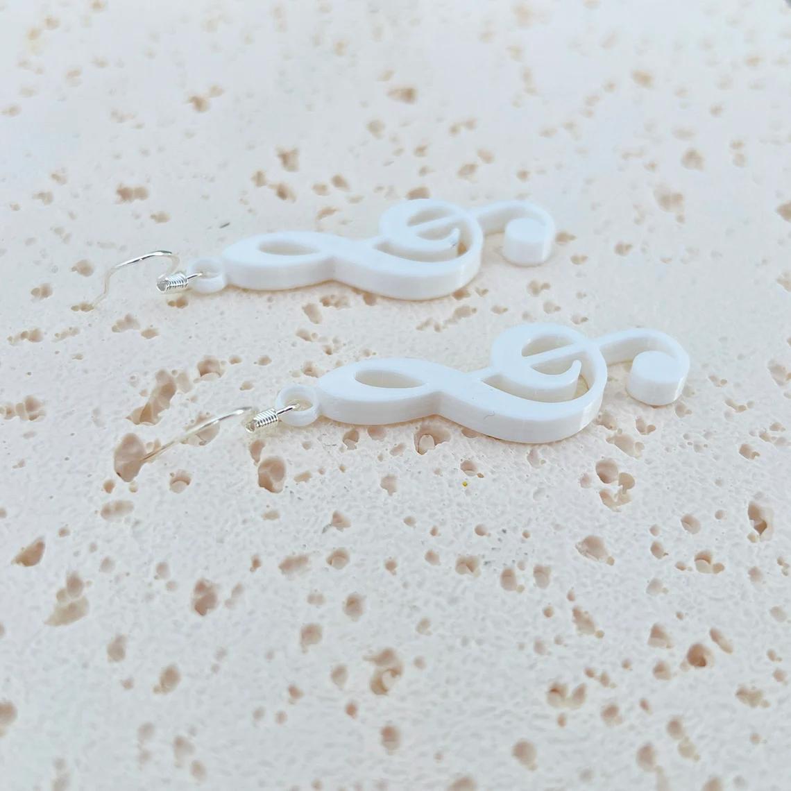 Elegant white treble clef dangle earrings made of 925 sterling silver and biobased plastic, perfect for any occasion.