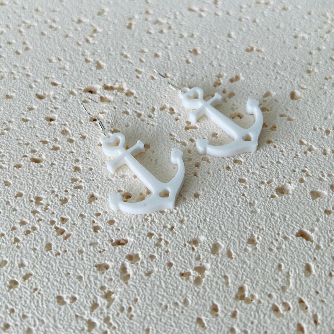 White anchor dangle earrings with sterling silver hooks, adding nautical elegance and movement to any outfit.