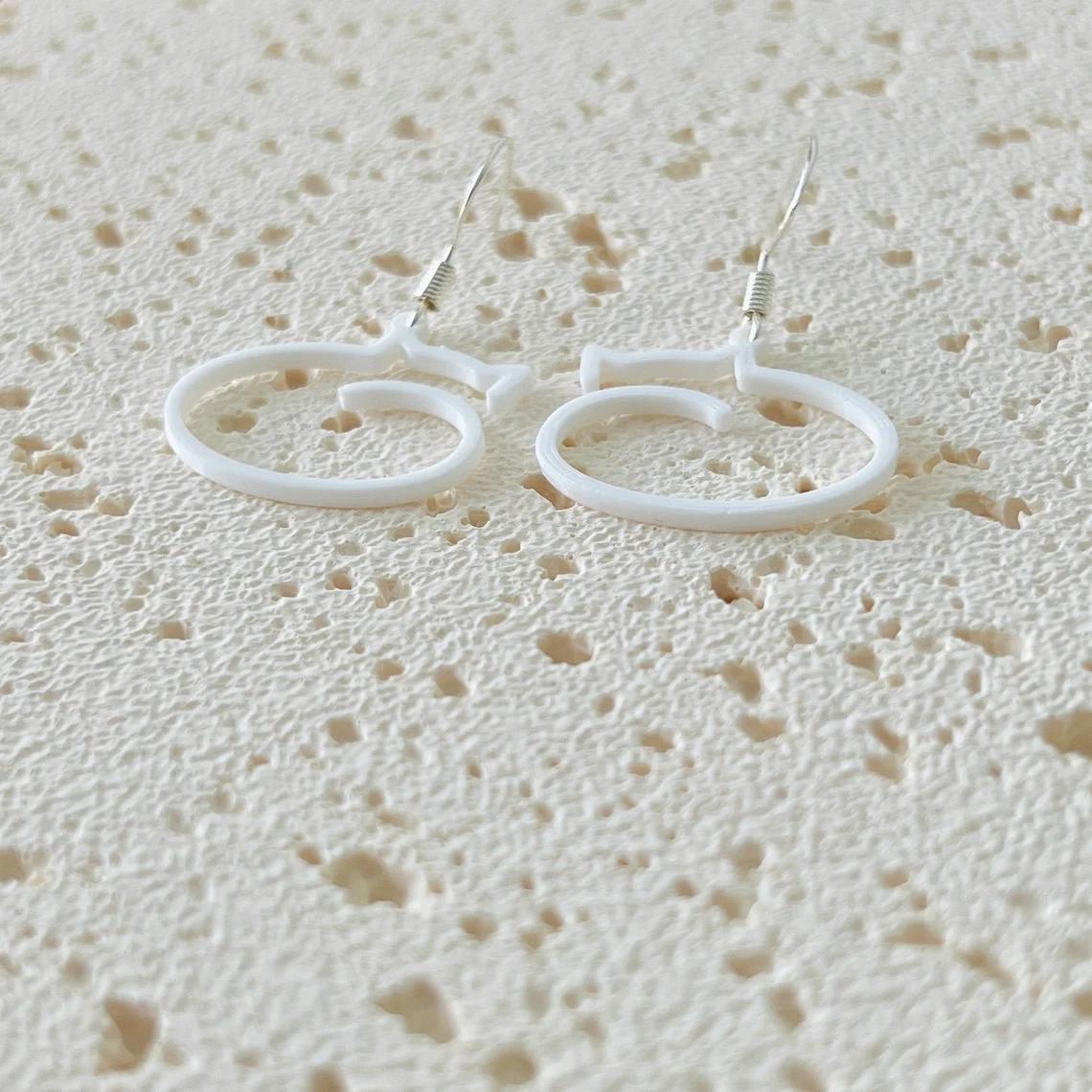 Whimsical cat dangle earrings in white biobased plastic, featuring 925 sterling silver hooks for comfortable wear.
