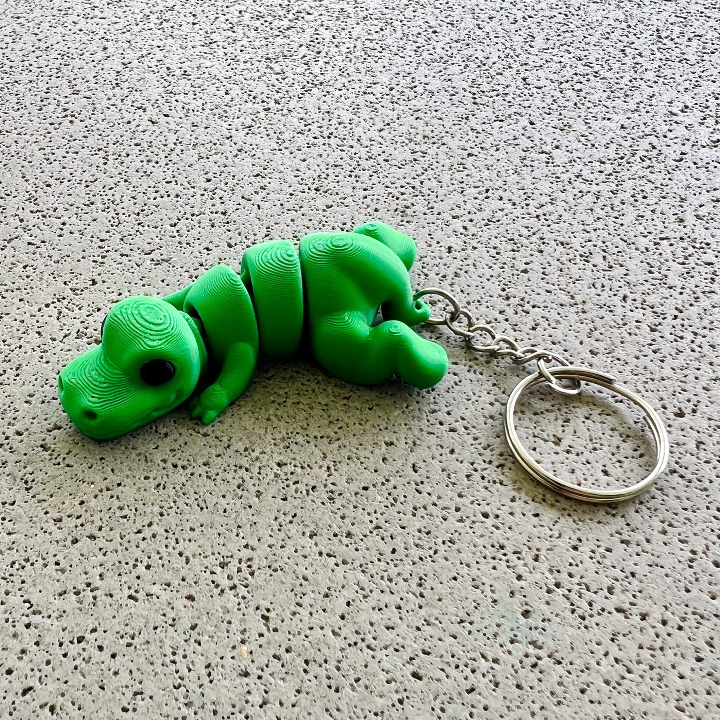 Vibrant green T-Rex keychain with detailed features, perfect for adding a fun prehistoric touch to your accessories.