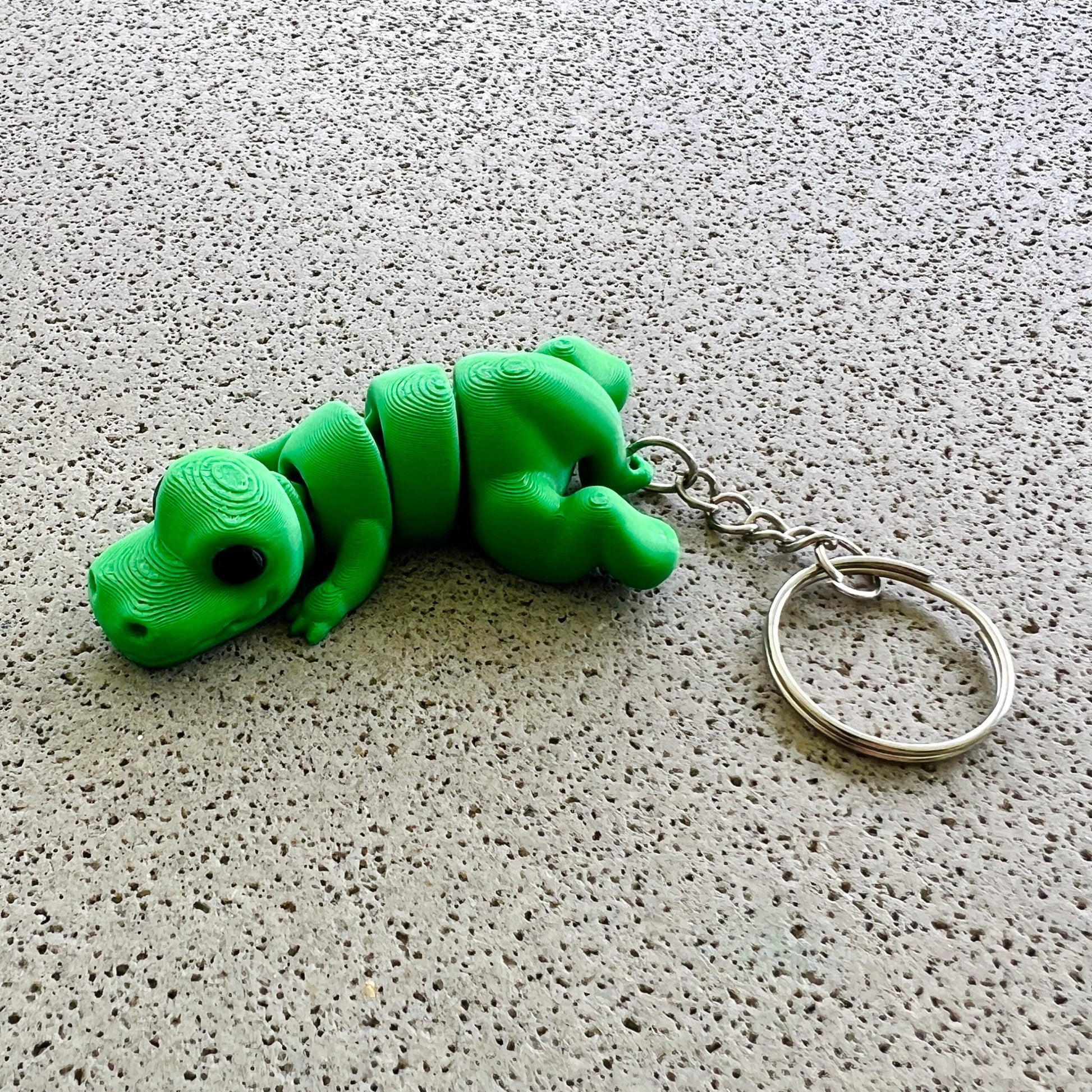 Vibrant green T-Rex keychain with detailed features, perfect for adding a fun prehistoric touch to your accessories.