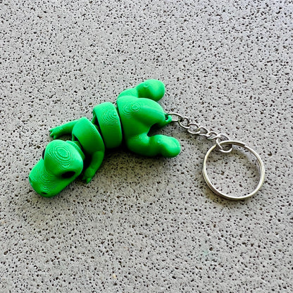 Bright green T-Rex keychain with detailed features, perfect for adding a fun, prehistoric flair to your accessories.