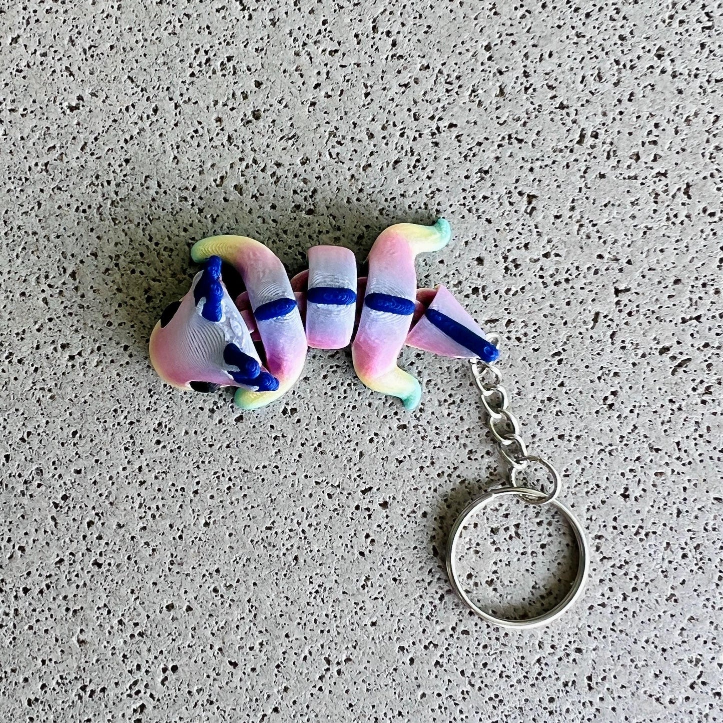 Vibrant rainbow axolotl keychain with whimsical colors and playful details, perfect for keys or bags.