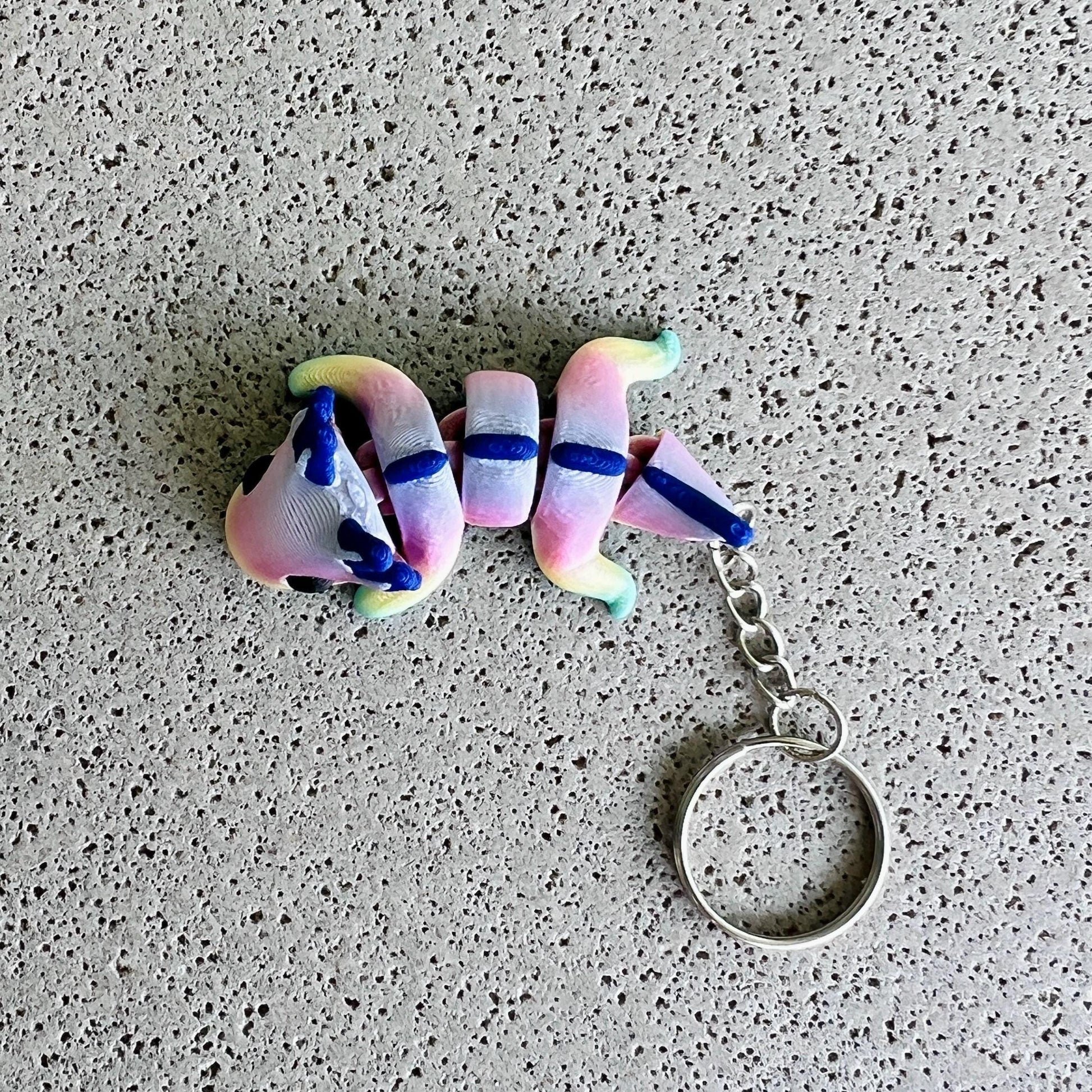 Vibrant rainbow axolotl keychain with whimsical colors and playful details, perfect for keys or bags.