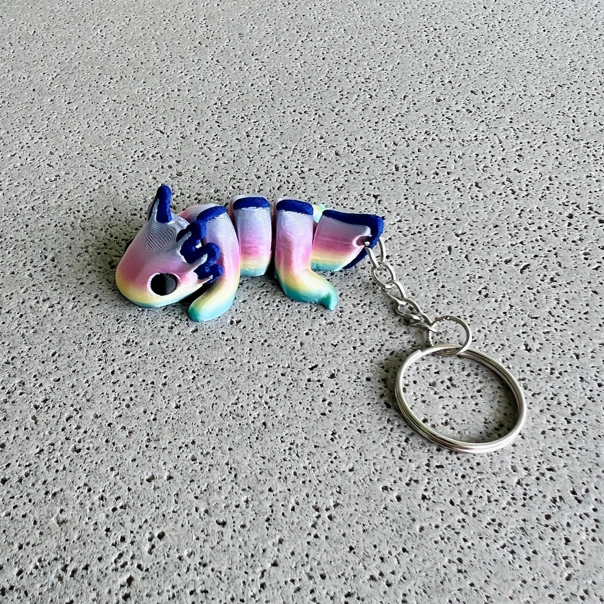 Vibrant rainbow axolotl keychain featuring pastel colors and a playful design, perfect for brightening up your belongings.