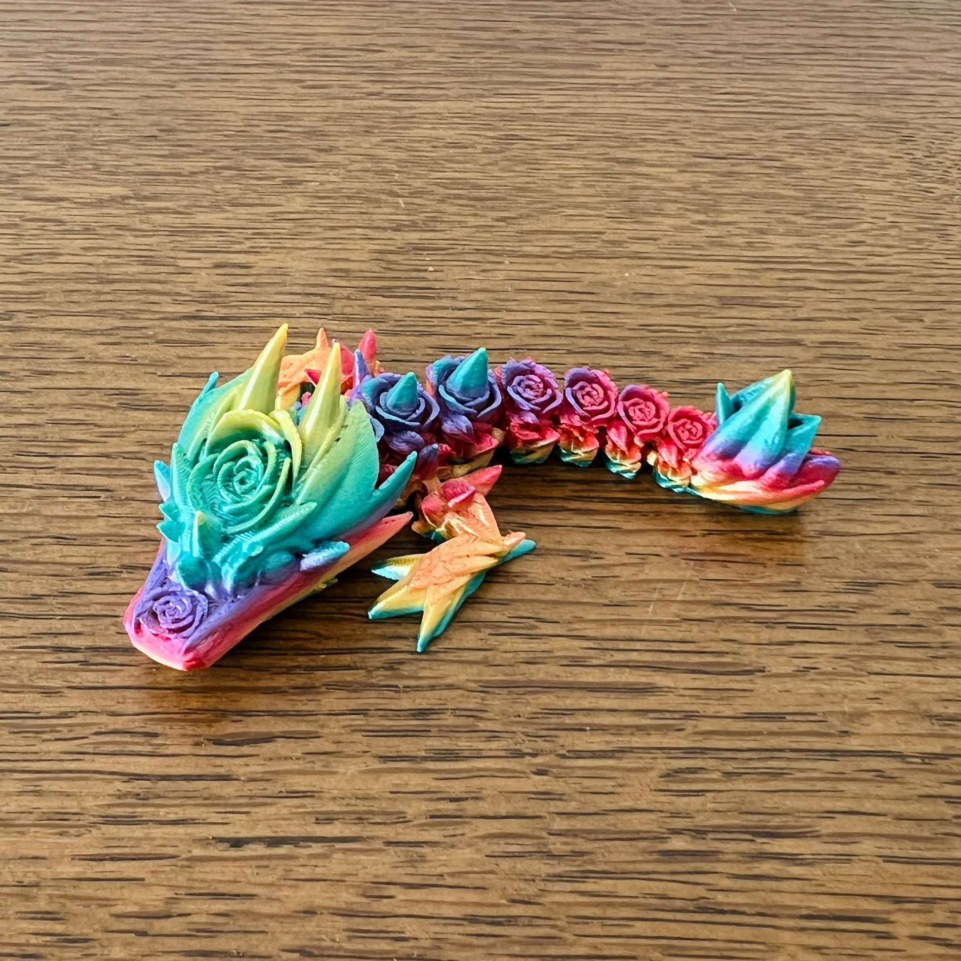 Colorful 3D rose dragon with intricate floral details, showcasing vibrant shades of blue, pink, and yellow.