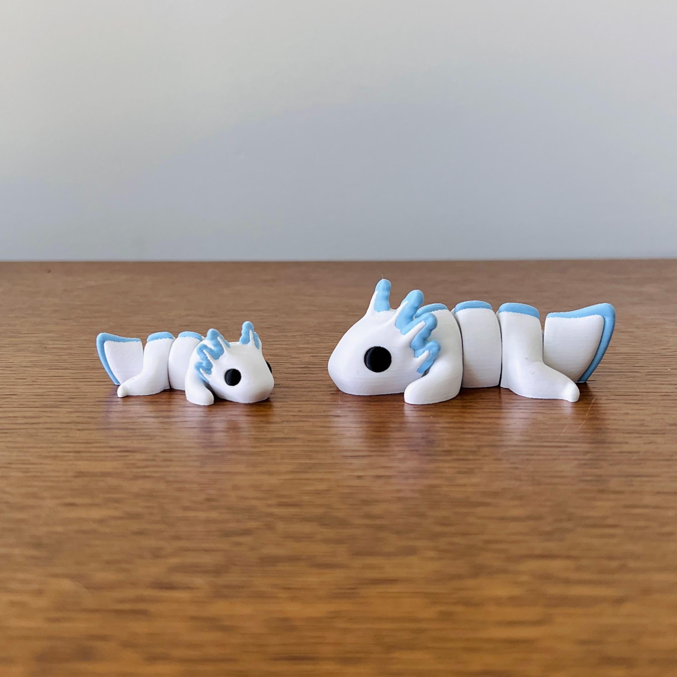 Charming white and pastel blue axolotls with articulated bodies, perfect for sensory play and stress relief.